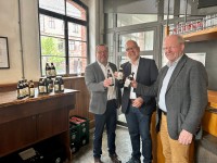Landrat und zwei Geschäftsführer stoßen auf das Bier zum Landkreisjubiläum an 